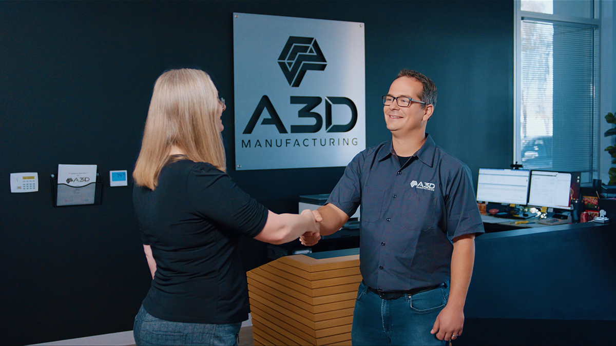 A3D Manufacturing team member shaking hands with a client.