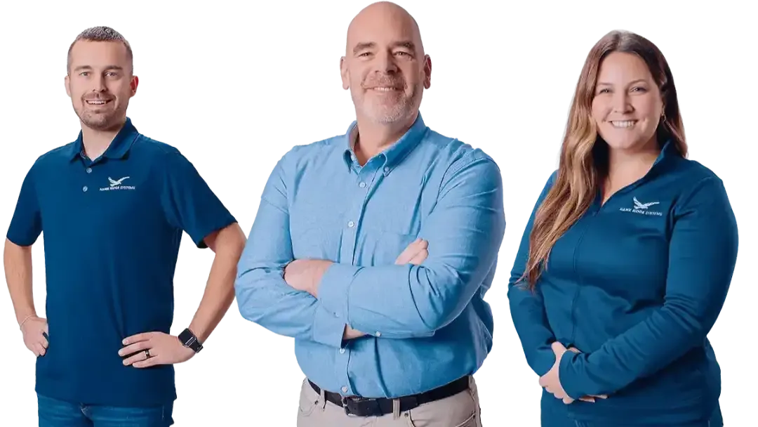 Three Hawk Ridge Systems team members in branded shirts standing with arms crossed