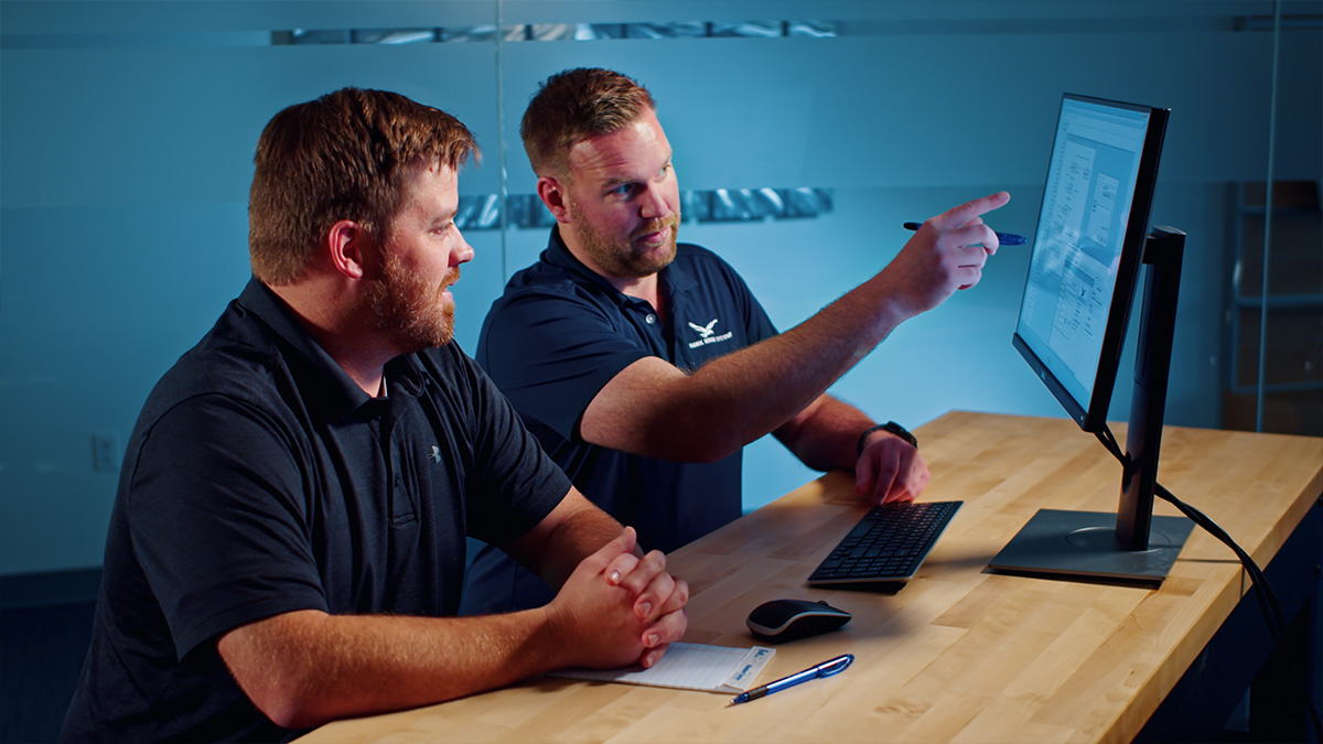 Hawk Ridge Systems support engineer pointing at a SOLIDWORKS screen while helping a customer
